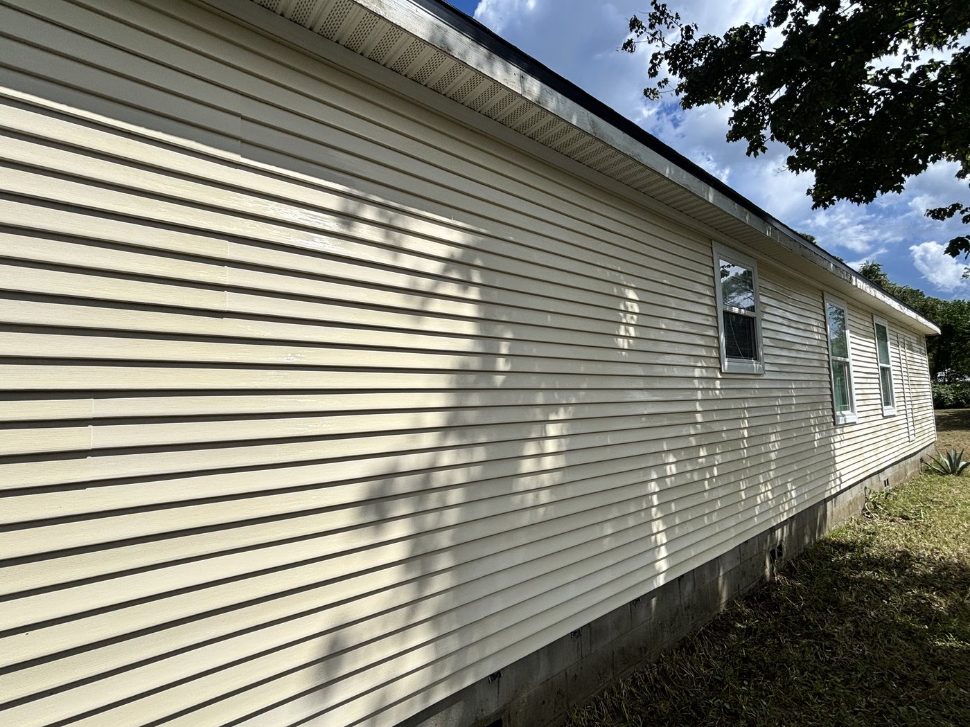 Same siding after soft washing, clean and bright